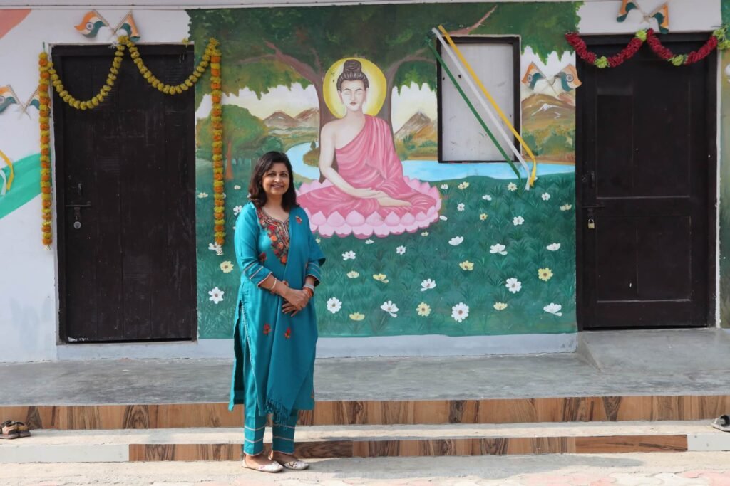 Founder Chhaya Sharma standing in front of a mural at UshaKiran Study Center, Sector 137, Noida