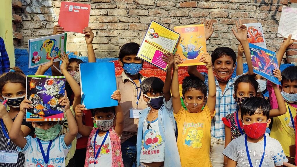 Volunteers distributing learning kits and essential items to children at Pehchaan Street School