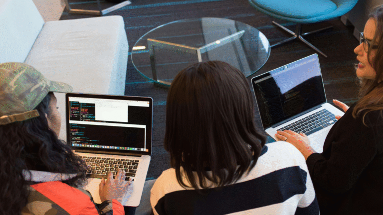 Young entrepreneurs collaborating on laptops at a tech event, illustrating teamwork and innovation for MSME Hackathon 4.0 success in Noida.