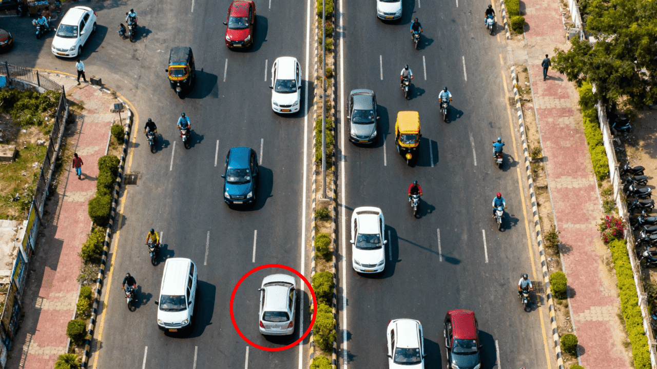 Aerial view of Noida road showing organized traffic with one car driving on the wrong side