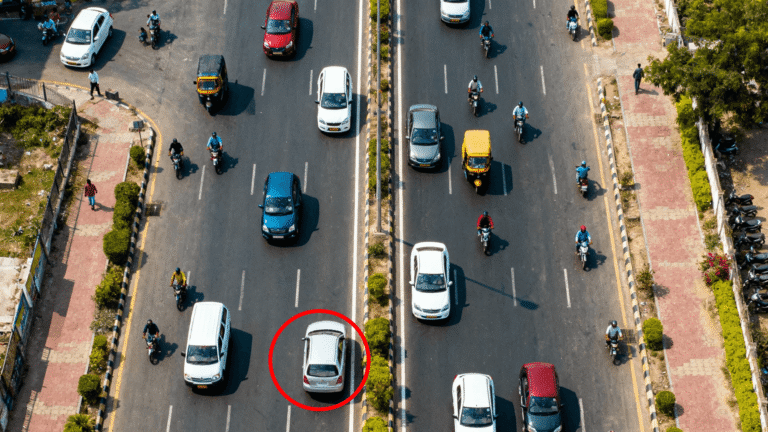 Aerial view of Noida road showing organized traffic with one car driving on the wrong side