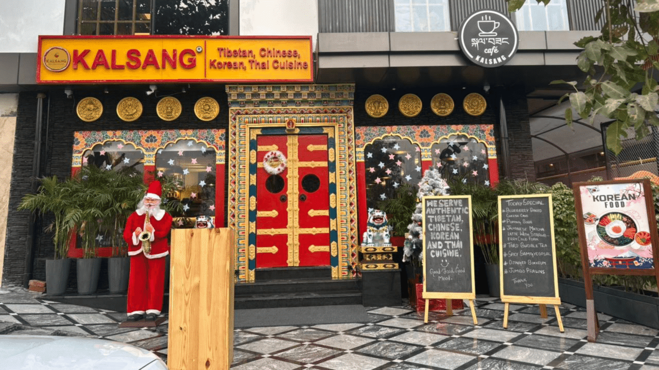 Kalsang Restaurant storefront with red Tibetan doors, yellow signage and gold Buddhist circles