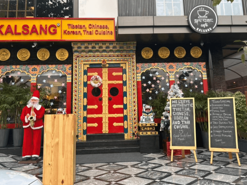 Kalsang Restaurant storefront with red Tibetan doors, yellow signage and gold Buddhist circles