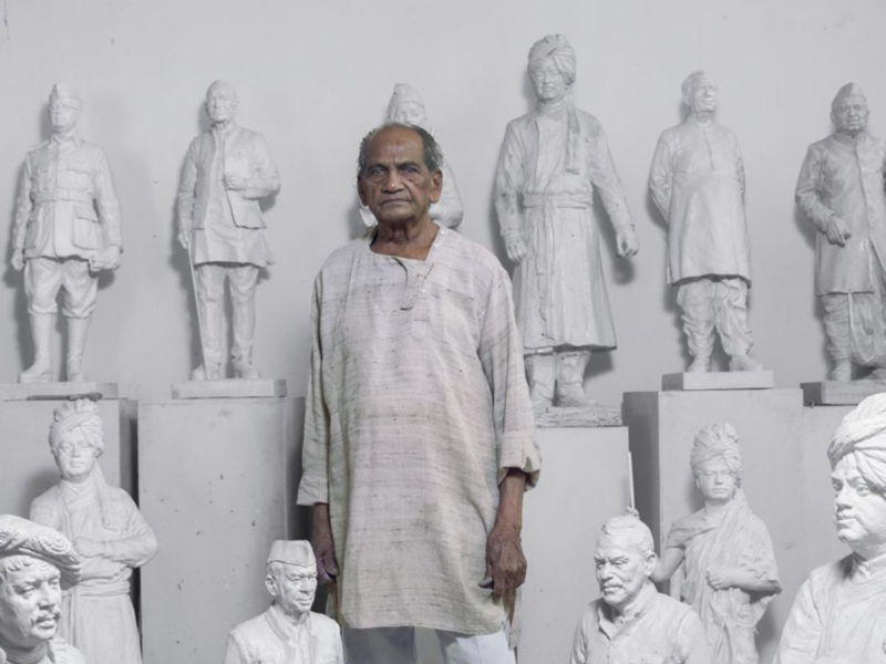 Indian sculptor Ram Sutar standing in his studio in Noida surrounded by white statue models of Indian leaders