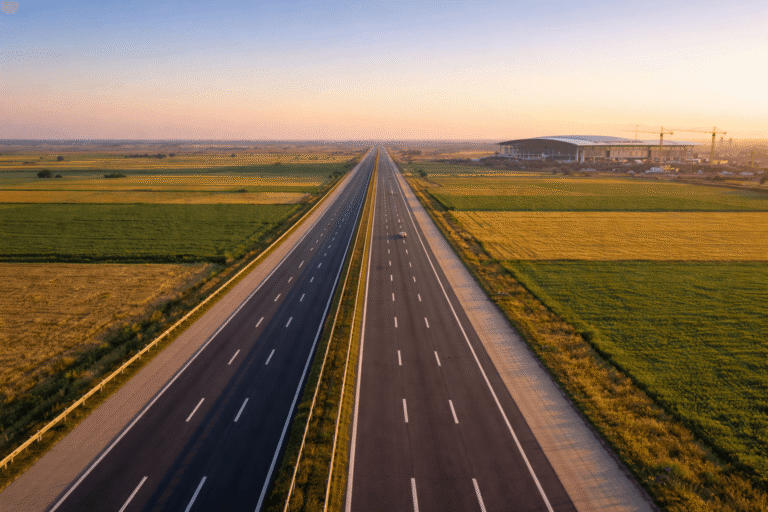 Aerial view of Yamuna Expressway near Greater Noida with Noida International Airport terminal and construction cranes visible in the background, 2026