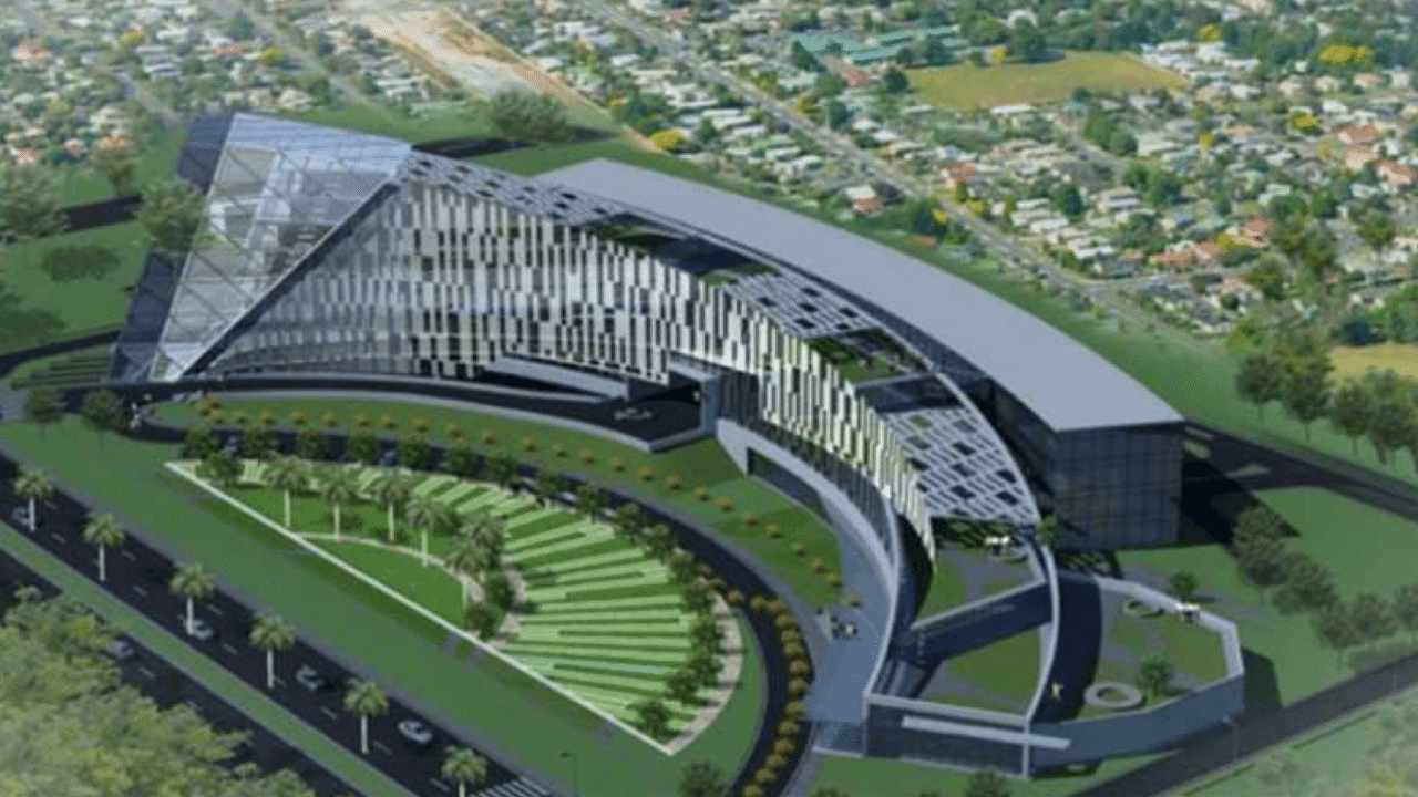 An aerial architectural rendering of the new Noida Authority headquarters in Sector 96, showcasing its modern curved glass facade and green landscaping.