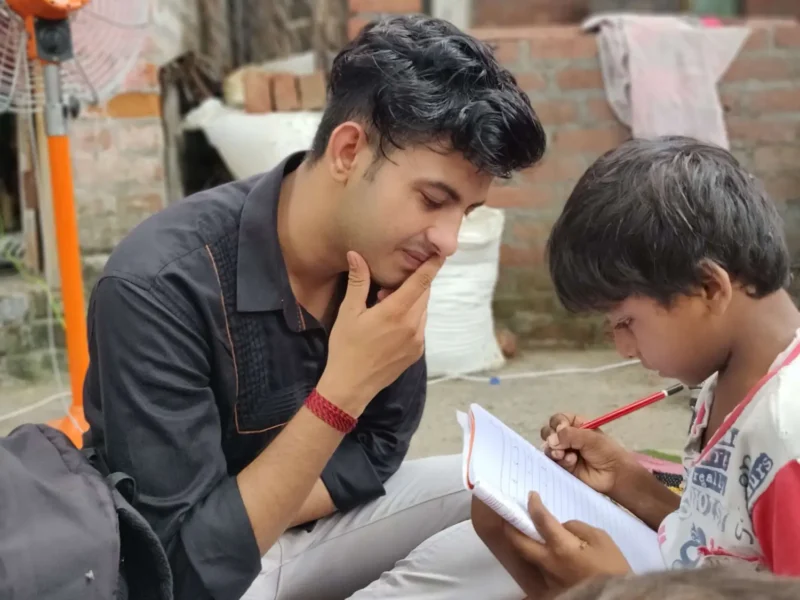 A Pehchaan The Street School volunteer helps a child during a learning session