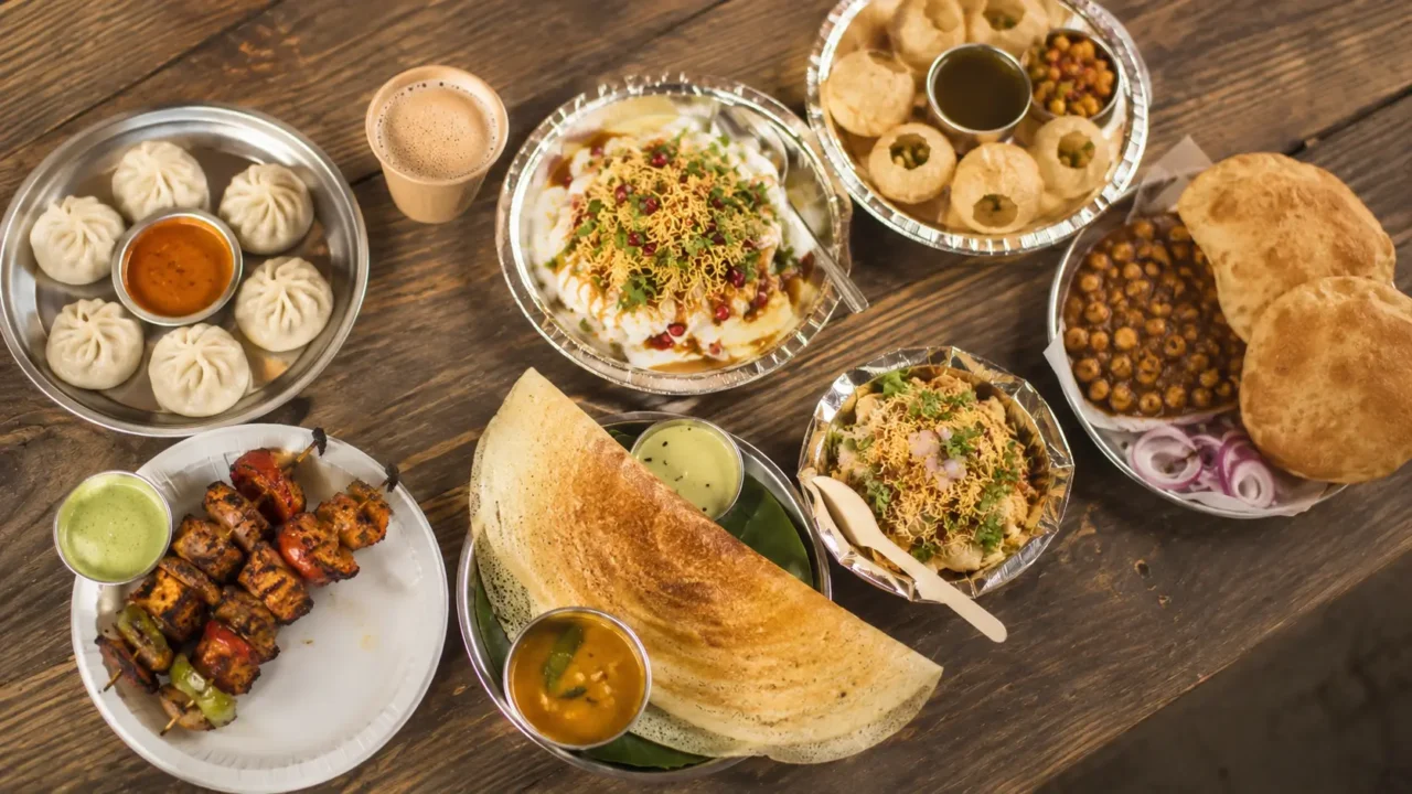 Top down view of Noida street food plates including dosa, momos, chaat, kebabs, pani puri and chole bhature
