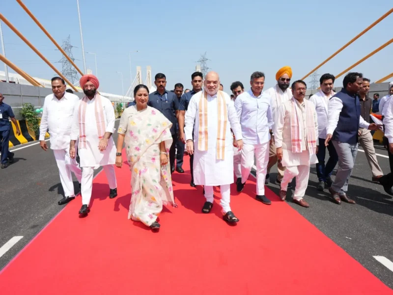 Amit Shah and other officials walking on a cable-stayed bridge during the Delhi road-project inauguration